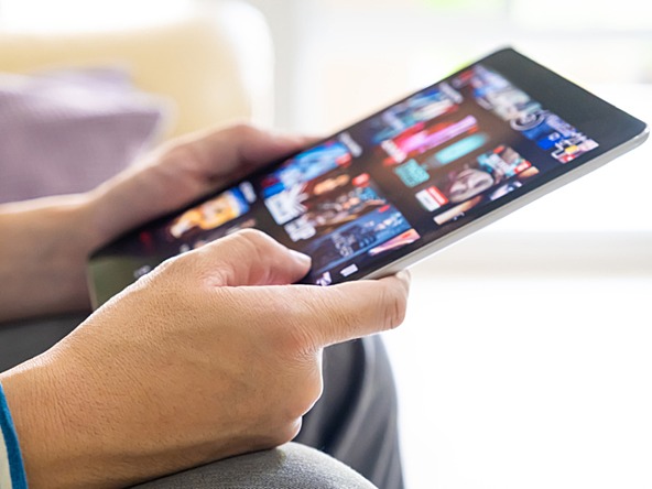 Young person choosing a streaming service on tablet device